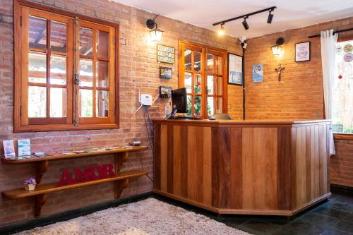 un bar in una stanza con un muro di mattoni di Pousada Suiça Mineira Garden a Monte Verde