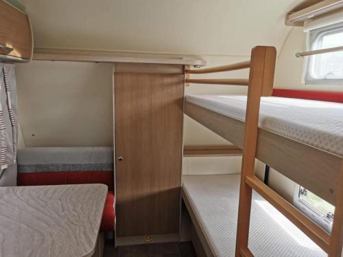 a small room with two bunk beds in a trailer at Familienwohnwagen im Emmental 
