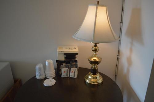 Circle 5 Motel في Olds: وجود مصباح على طاولة بجانب جهاز صنع القهوة