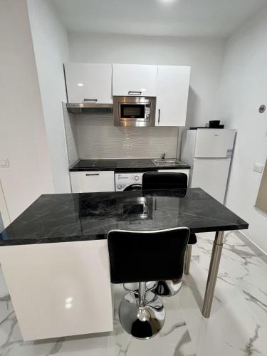 a kitchen with a table and a microwave at Edificio Rambla Pulido in Santa Cruz de Tenerife