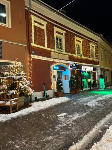 a building with a christmas tree on a snowy street at HOSTEL LOVELY ROOMS CITY CENTER, shared Bathroom in Villach