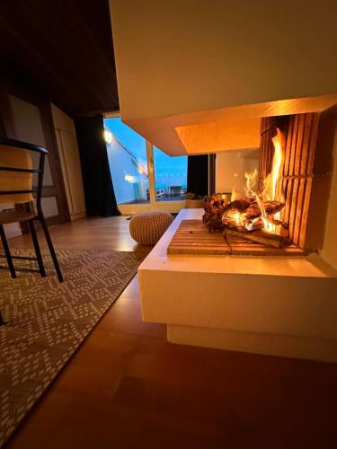 a fireplace in a living room with a fire in it at Solo Atico Guest Suites in L'Escala