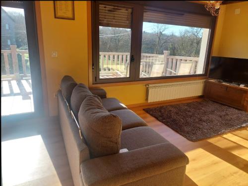 a living room with a couch and a flat screen tv at Apartamento Quinfon in Maceda