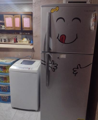 a refrigerator with a face drawn on it in a kitchen at شقه قريبه من الاهرامات والمتحف in Cairo