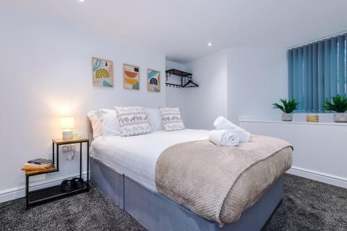 a white bedroom with a bed and a window at Spacious modern apartment in central location - free parking in Liverpool