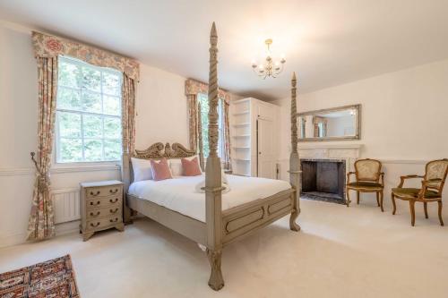 a bedroom with a four poster bed and a fireplace at Royal Windsor Mansion Private 5 Acre Luxury Escape in Windsor