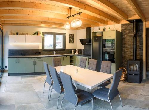 a kitchen with a table and chairs in a room at Chalet cosy 4 étoiles le Domaine Des Mésanges in Plainfaing