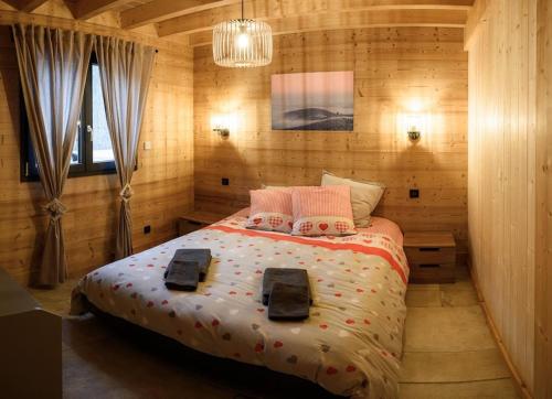a bedroom with a bed in a wooden room at Chalet cosy 4 étoiles le Domaine Des Mésanges in Plainfaing