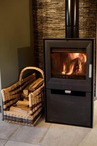 a fireplace with a fire in it in a living room at Chalet cosy 4 étoiles le Domaine Des Mésanges in Plainfaing