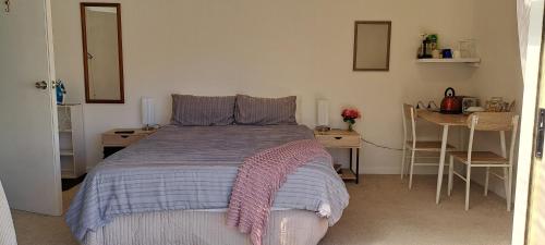 a bedroom with a bed and a table and chairs at 15 On Wards in Greytown
