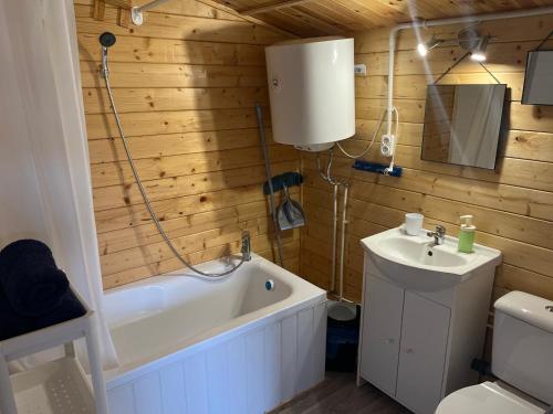 ein Badezimmer mit einer Badewanne, einem Waschbecken und einem WC in der Unterkunft Swojskie Chatki - Marynarska Chatka in Smołdziński Las