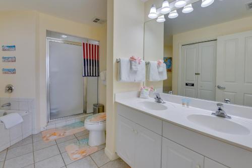 a bathroom with two sinks and a toilet and a mirror at Sunny Fort Walton Beach Condo - Walk to Ocean! in Fort Walton Beach