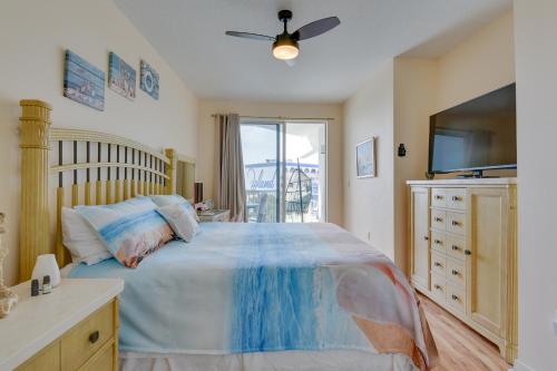 a bedroom with a large bed with a ceiling fan at Sunny Fort Walton Beach Condo - Walk to Ocean! in Fort Walton Beach
