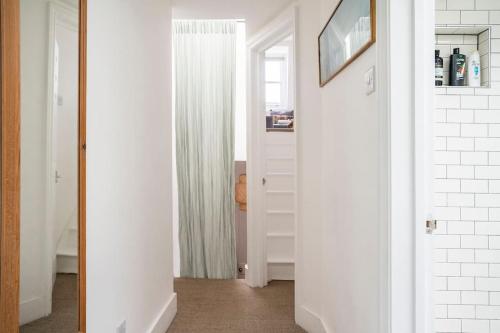 un pasillo con una puerta blanca y una ventana en North East London loft apartment. Stoke Newington., en Londres