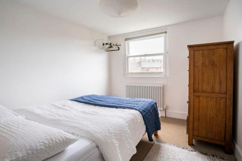 1 dormitorio con cama y ventana en North East London loft apartment. Stoke Newington., en Londres