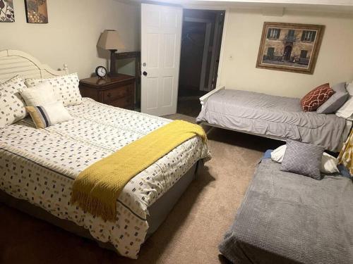 um quarto com 2 camas e um repousa-pés em Streamview Retreat near I-77/40 em Statesville