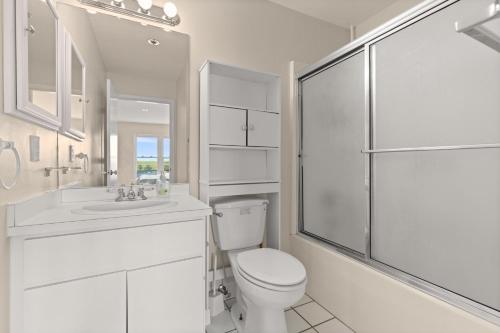 a white bathroom with a toilet and a shower at Oceanfront Villa 1 - Boardwalk Oceanfront in Ocean City