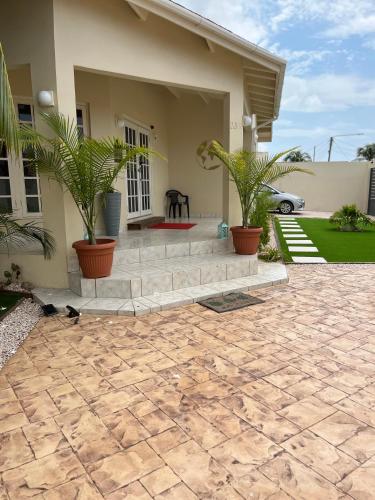 a house with a patio with plants in front of it at La Villas at Pos Chiquito Caribbean Paradise in Aruba in Savaneta