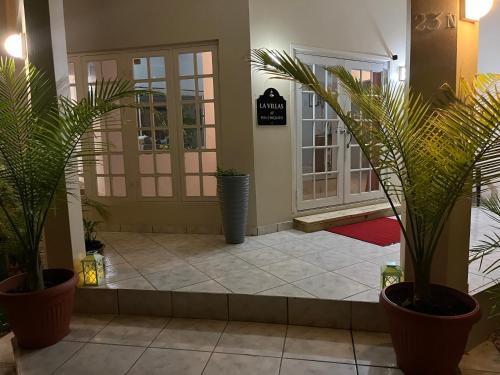a lobby with potted plants in front of a door at La Villas at Pos Chiquito Caribbean Paradise in Aruba in Savaneta