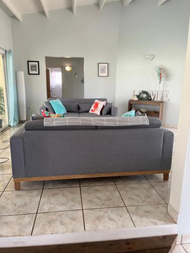 a gray couch in a living room with at La Villas at Pos Chiquito Caribbean Paradise in Aruba in Savaneta