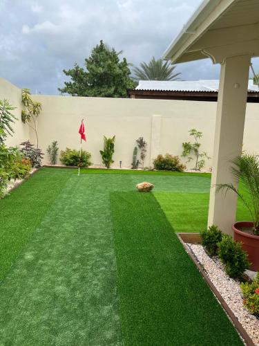 a yard with green grass and a building at La Villas at Pos Chiquito Caribbean Paradise in Aruba in Savaneta