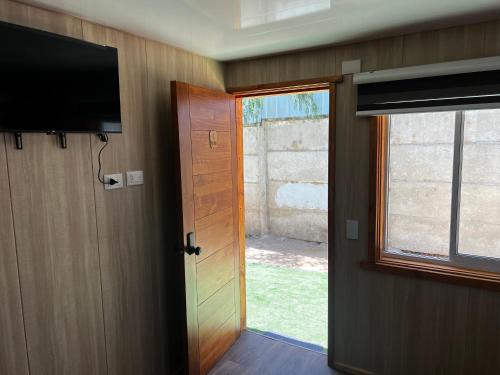 an open door to a room with a television and a door at Alojamiento Rústico Belloto 4 in Quilpué