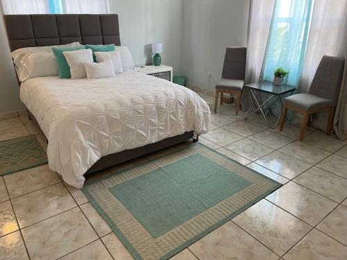 a bedroom with a large bed and two chairs at La Villas at Pos Chiquito Caribbean Paradise in Aruba in Savaneta