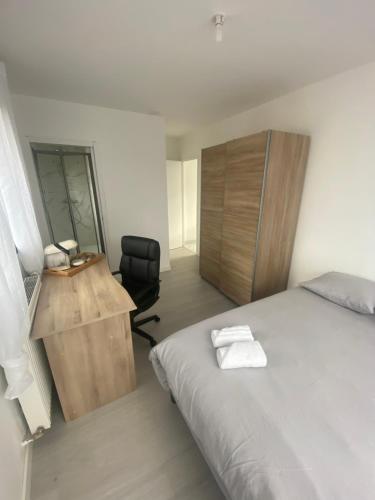 1 dormitorio con cama, escritorio y silla en Chambre double balcon vue mer, en Brest
