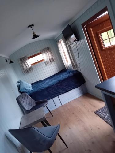 a small room with a bed and a chair at Carlingford Glamping Hut 