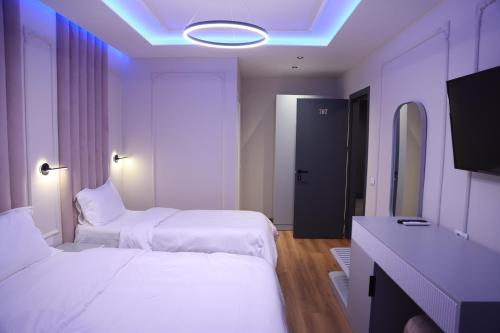 a hotel room with two beds and a tv at Sky View Hotel & Restaurant in Kukës