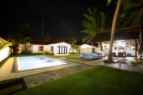 a villa with a swimming pool at night at Oasys House - Beautiful Private Beach Front Home in Msambweni