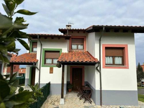 a small white house with a red roof at Los Castros Apartamentos Rurales A in Llames de Pría