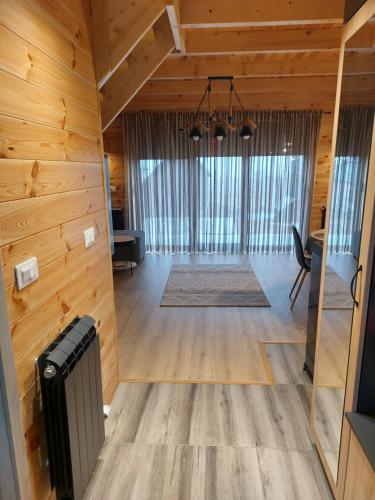 a large living room with wooden walls and a large window at Snowflake in Žabljak