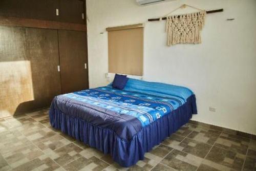 um quarto com uma cama azul num quarto em Villa Los Nonos em Mérida