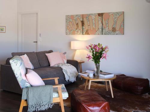 a living room with a couch and a table with flowers at Shawwood Estate in Mudgee