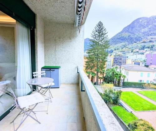 uma varanda com uma mesa e cadeiras e uma vista em Jacks Haus em Lugano