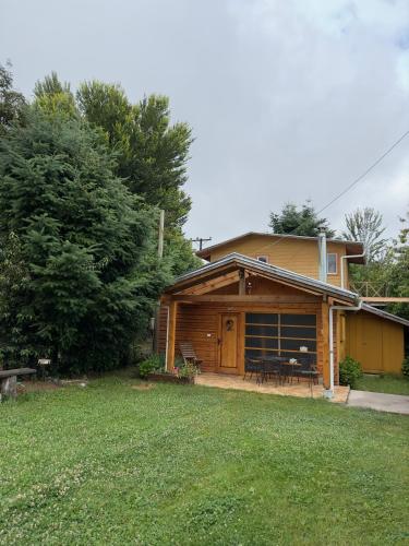 a log house with a porch and a yard at CABAÑAS Mony in Pucón