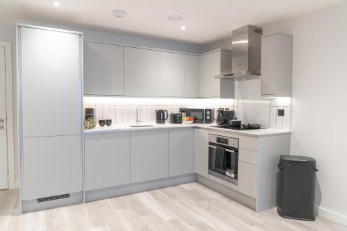 a white kitchen with white cabinets and appliances at Apex Lofts Suite - Modern 2 bed with rooftop terrace in Birmingham