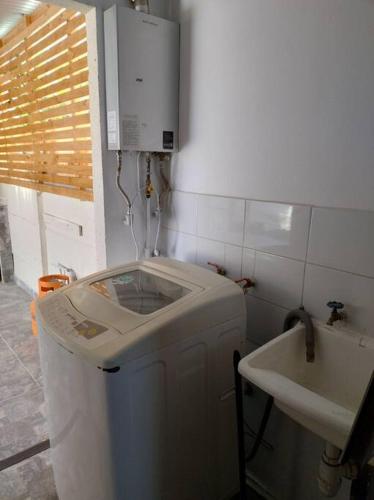 y baño con lavadora y lavamanos. en Arriendo diario Duplex La Serena en La Serena