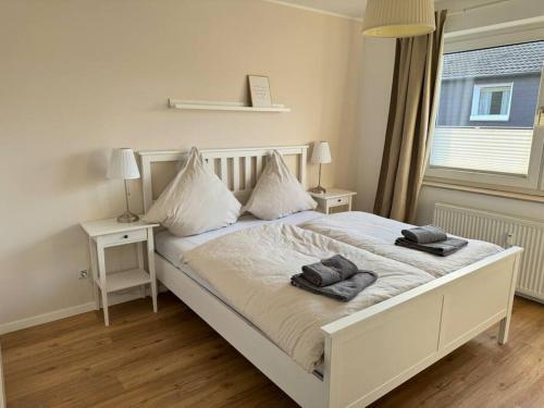 ein Schlafzimmer mit einem weißen Bett mit zwei Handtüchern darauf in der Unterkunft Sanierte 2 Zimmer Wohnung am CentrO in Oberhausen in Oberhausen