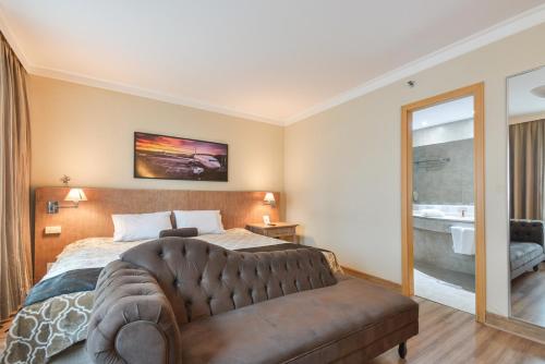um quarto com uma cama grande e um sofá em Premium room Berrini em São Paulo