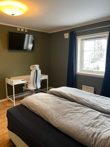 1 dormitorio con 2 camas, escritorio y TV en Stue, soverom og bad en Åmot