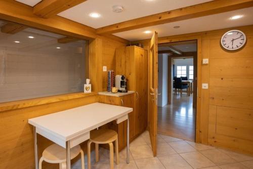 eine Küche mit einem Tisch, Stühlen und einer Uhr in der Unterkunft Ferienwohnung Wintersberg in Ebnat