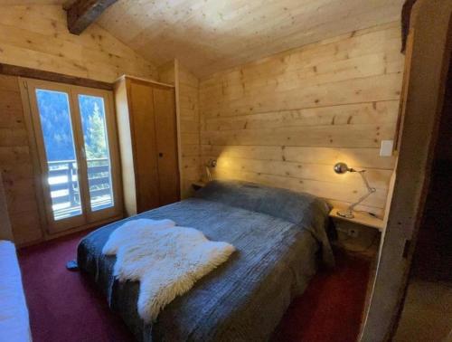 a bedroom with a bed and a desk with a lamp at Chalet familial in Grimentz