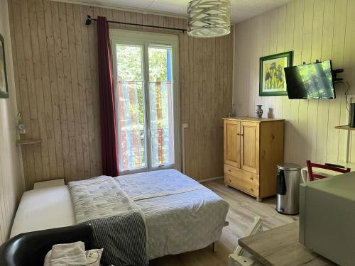 um pequeno quarto com uma cama e uma janela em Studio avec wifi a Neris les Bains em Néris-les-Bains