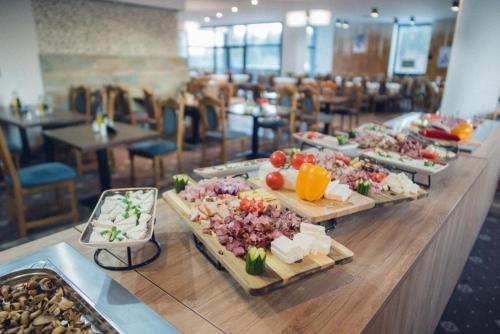 una linea a buffet con diversi tipi di cibo sopra di Luxury Apartment Silver Mountain Vue a Poiana Brasov