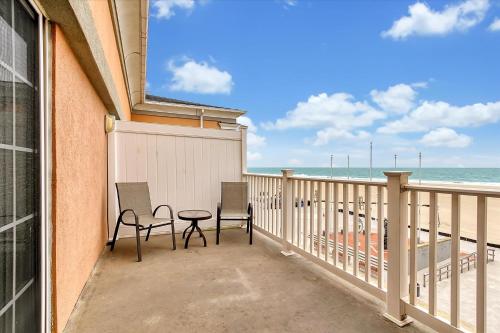 a balcony with two chairs and a table on the beach at Oceanfront Villa 4(109) Boardwalk Oceanfront in Ocean City