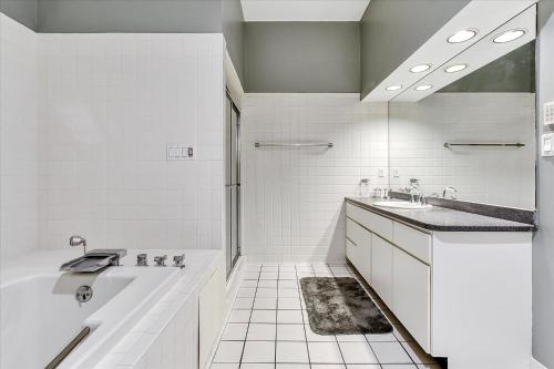 a white bathroom with a tub and a sink at Oceanfront Villa 2(103) - Boardwalk oceanfront in Ocean City