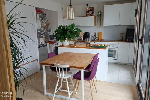 a kitchen with a wooden table and purple chairs at Appartement avec terrasse in Saint-Denis