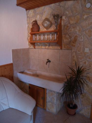 a bathroom with a sink in a stone wall at Apartments PHARIA in Jelsa